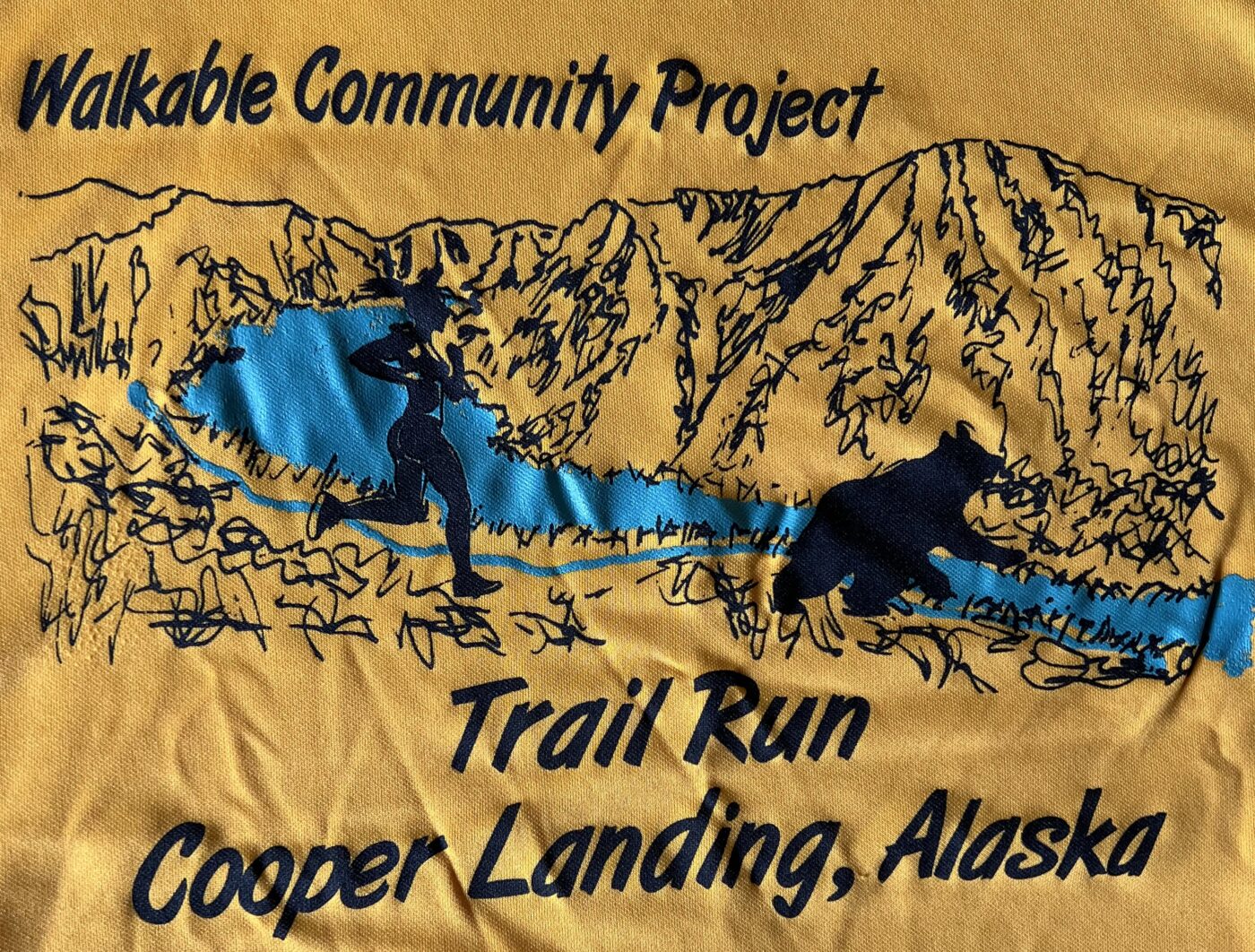 Walkable Community Project. Image of mountains, lake, river, silhouette of black bear ahead of a female runner. Trail Run Cooper Landing, Alaska